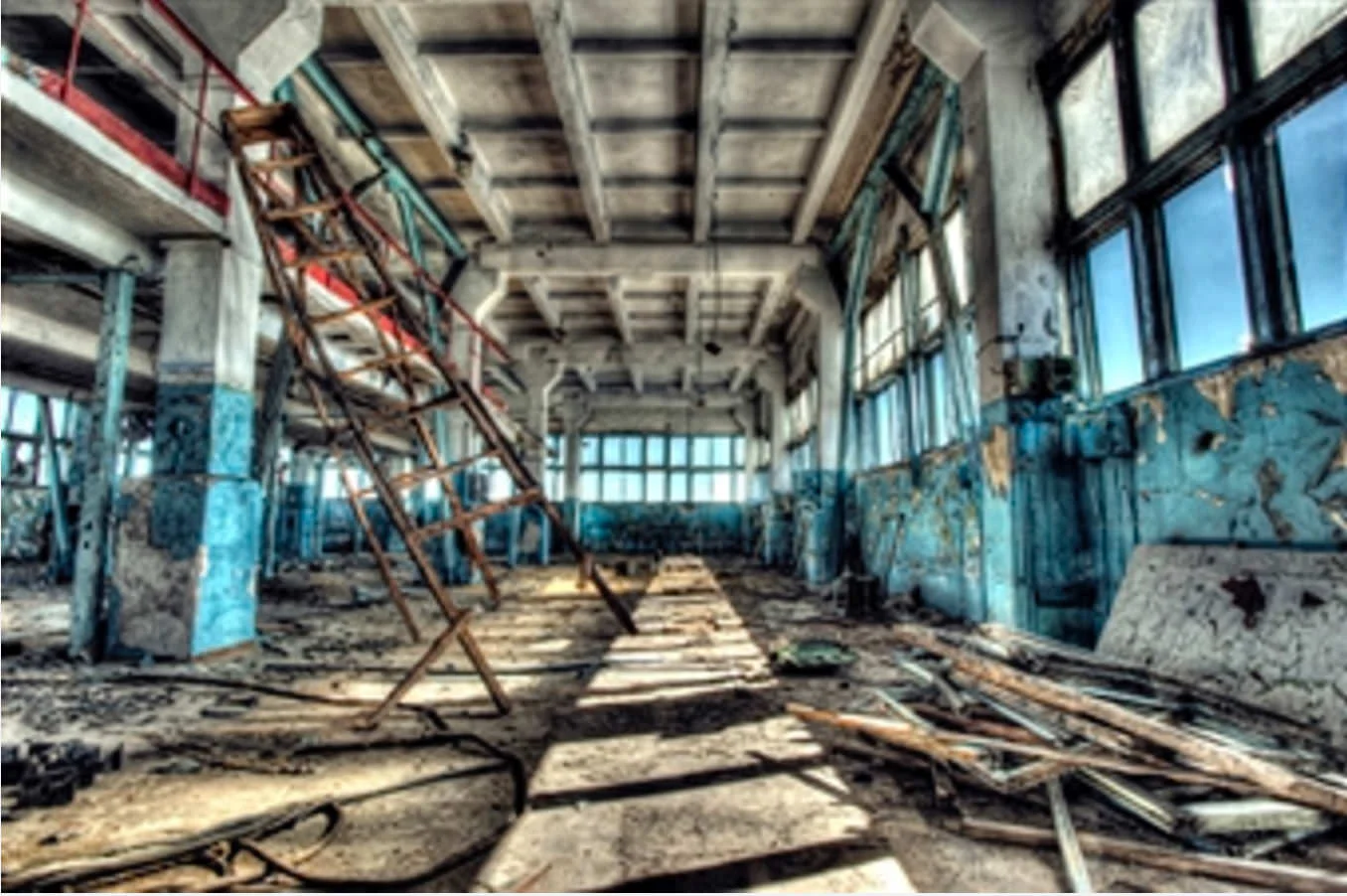 Empty factory floor with falling ladder left of center. This image represents all personal injury.