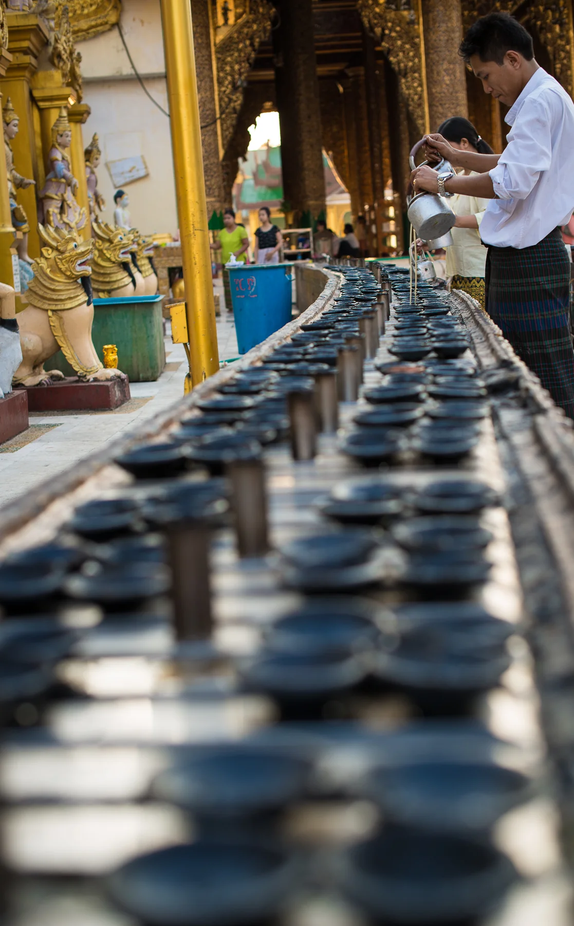 Oil lamps being filled at Shwedagon Pagoda.  Yangon, Myanmar