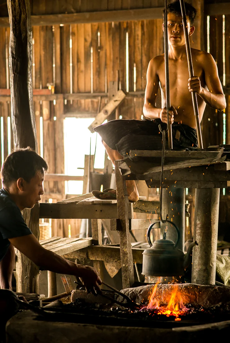 Working the bellows in a blacksmith shop. Inle Lake, Myanmar