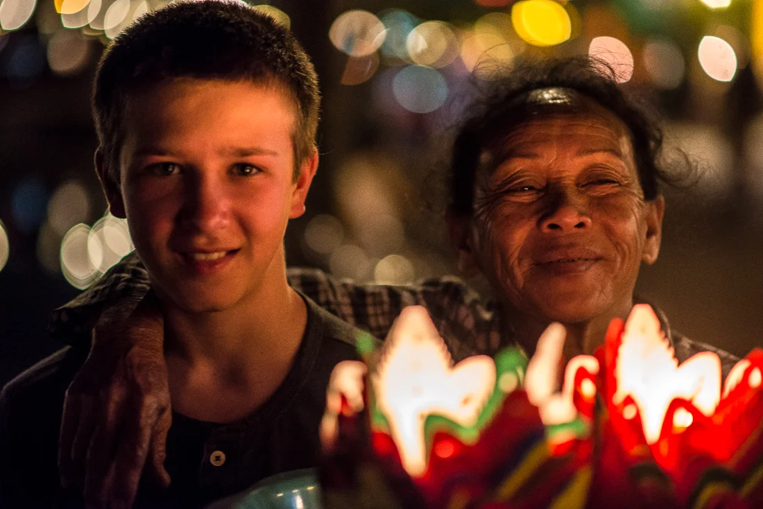 My Nephew and an old lady selling floating candles to send down the river. I'm assuming to make a wish and for good luck. Old Town. Hoi An, Vietnam
