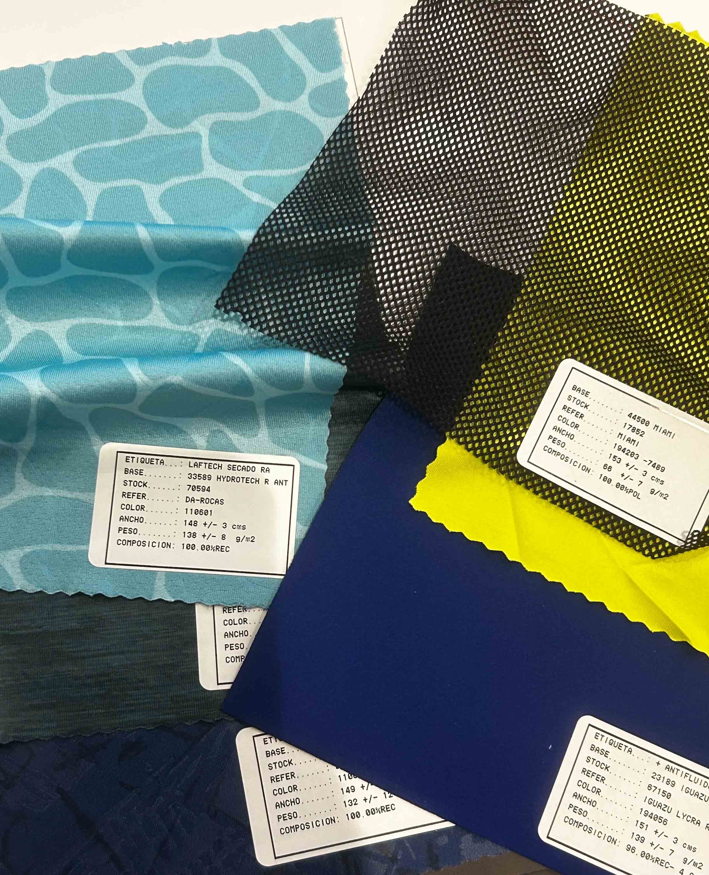 Samples of different colored and patterned fabrics with labels showing specifications.