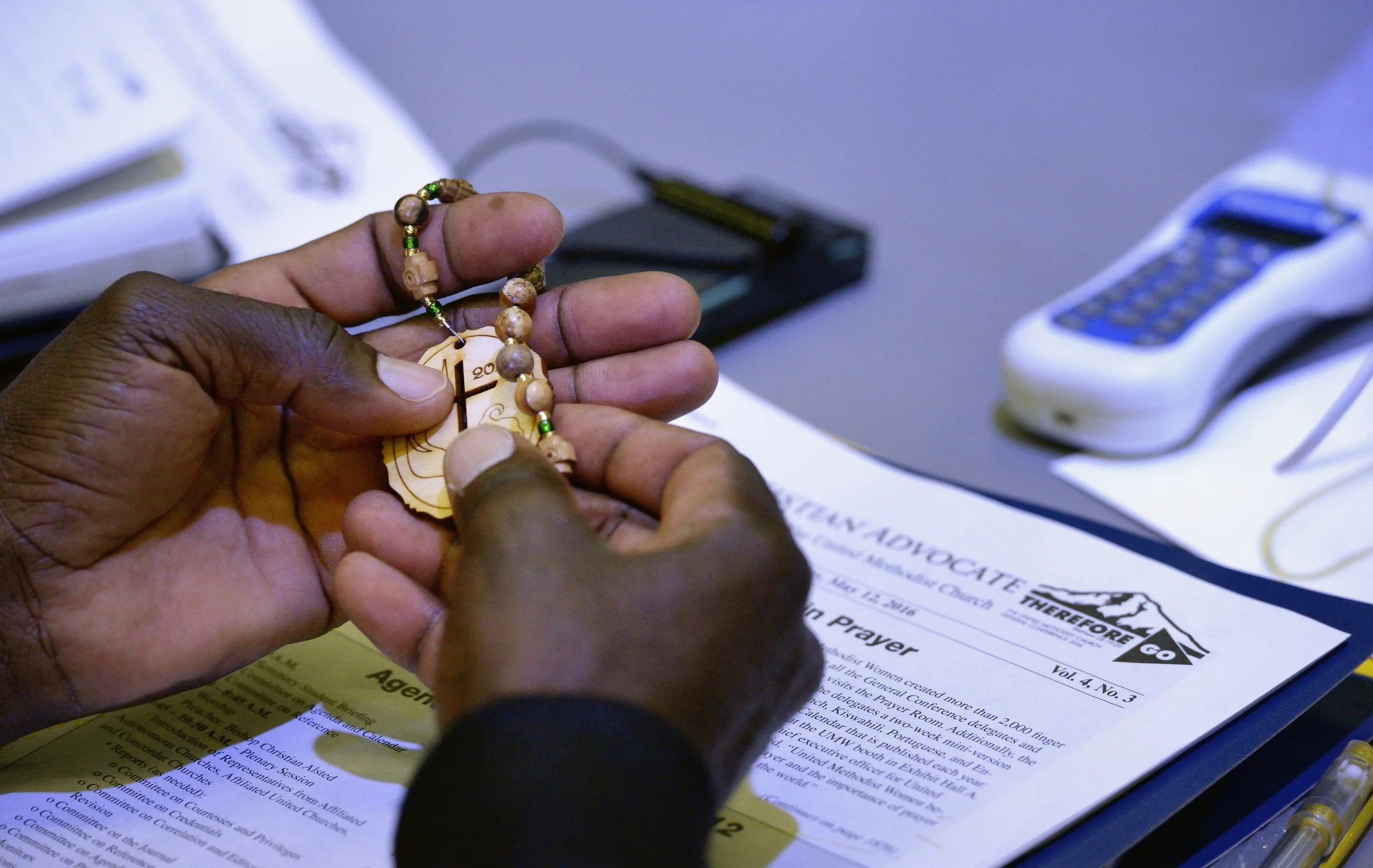 A delegate handles prayer beads during prayer. The beads were distributed to all participants. Photo credit: Paul Jeffrey, UMNS.