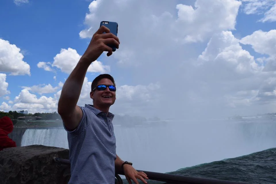 Nick taking a selfie at Niagara Falls with the youth this summer on their Choir Tour.