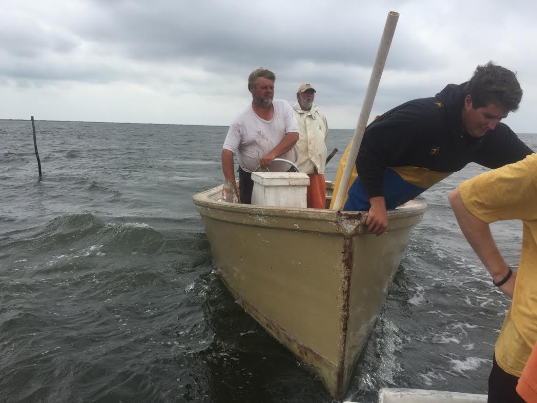 Eddie Willis steers his handmade boat with his son at the front