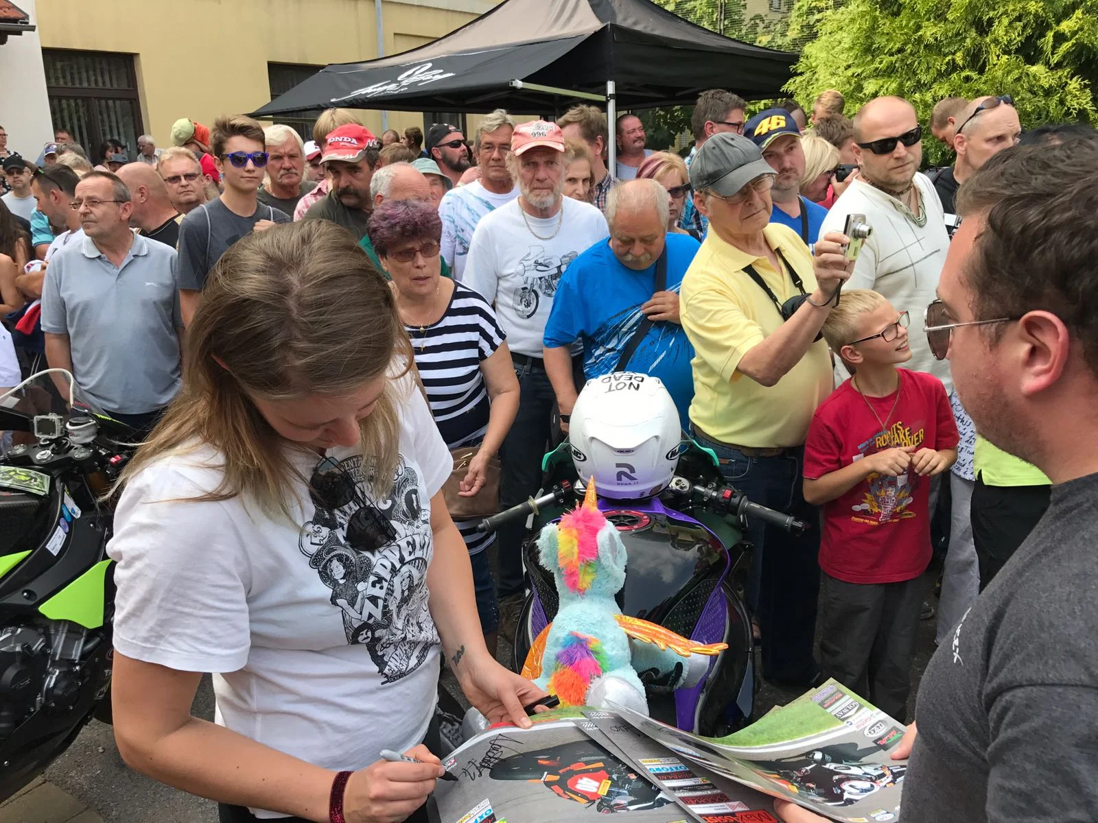 Signing posters during the rider presentation.