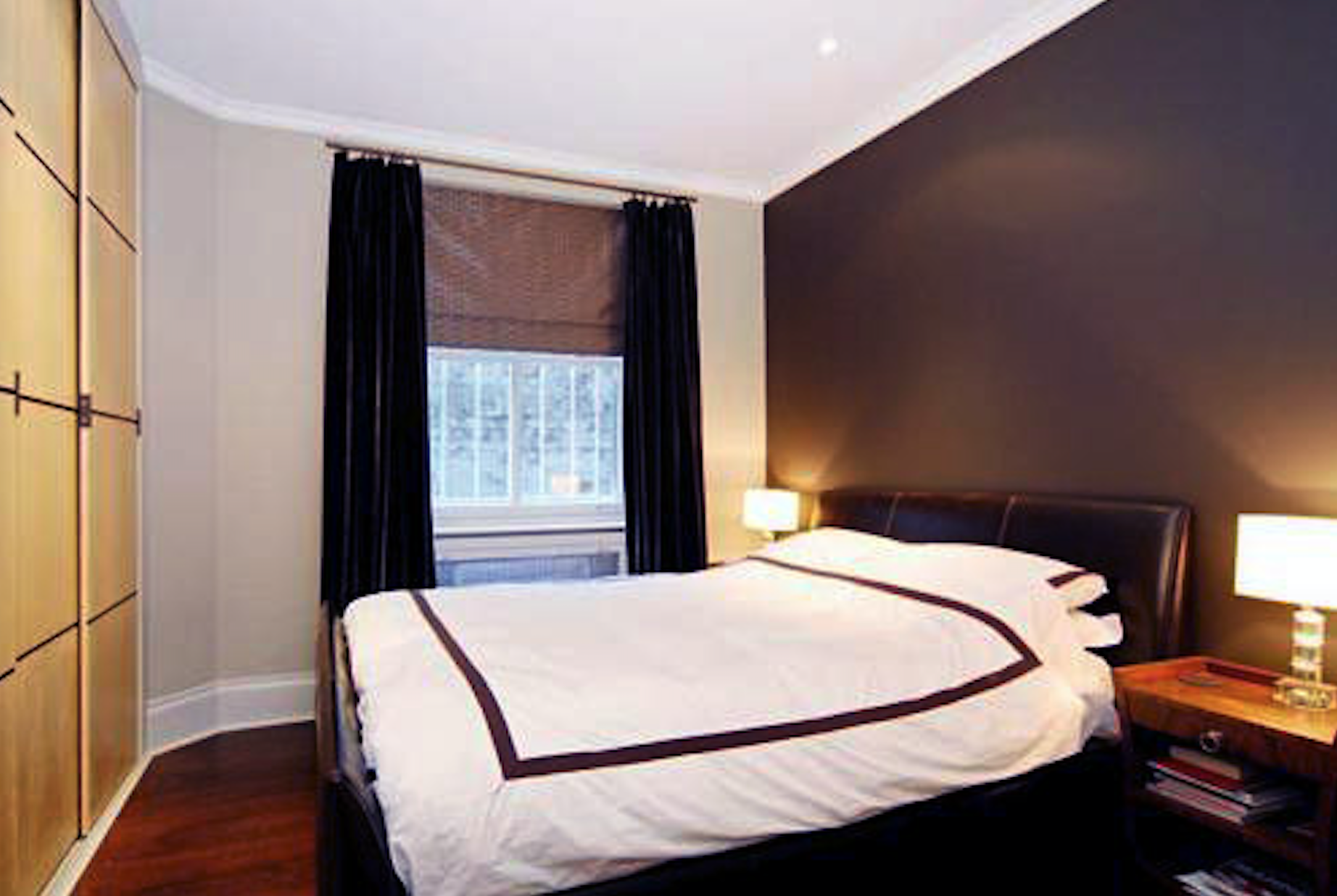 Master bedroom with Art Deco side tables, velvet curtains