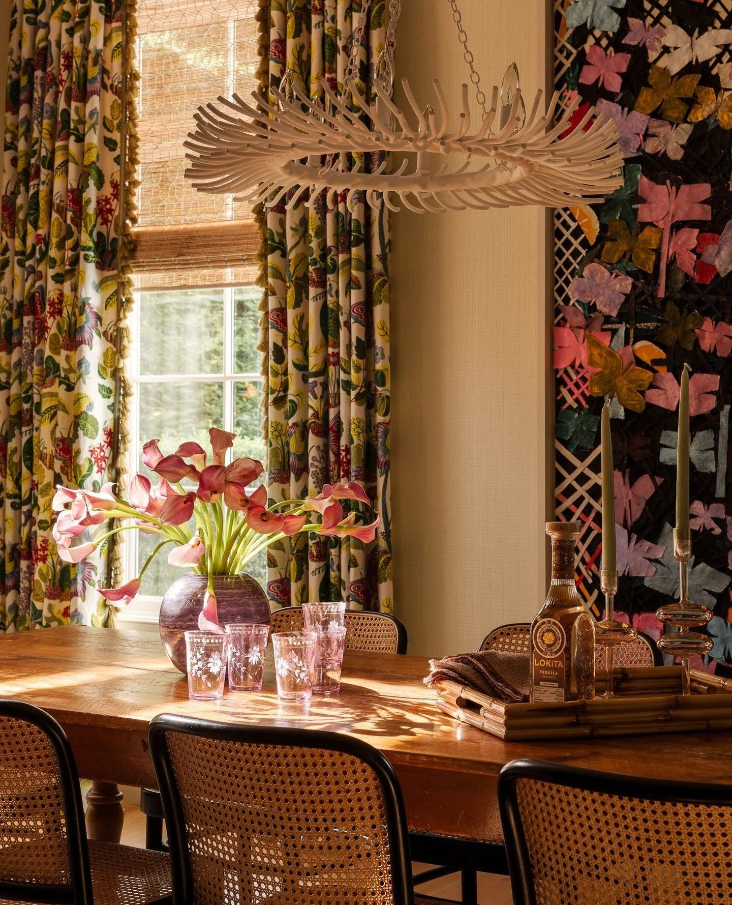 Evening light spills across the dining table&mdash;an inviting scene after a day spent by the pool or beach. The warmth of natural textures and patterned drapery, designed in collaboration with Sara Gilbane, reflect the home&rsquo;s relaxed rhythm an