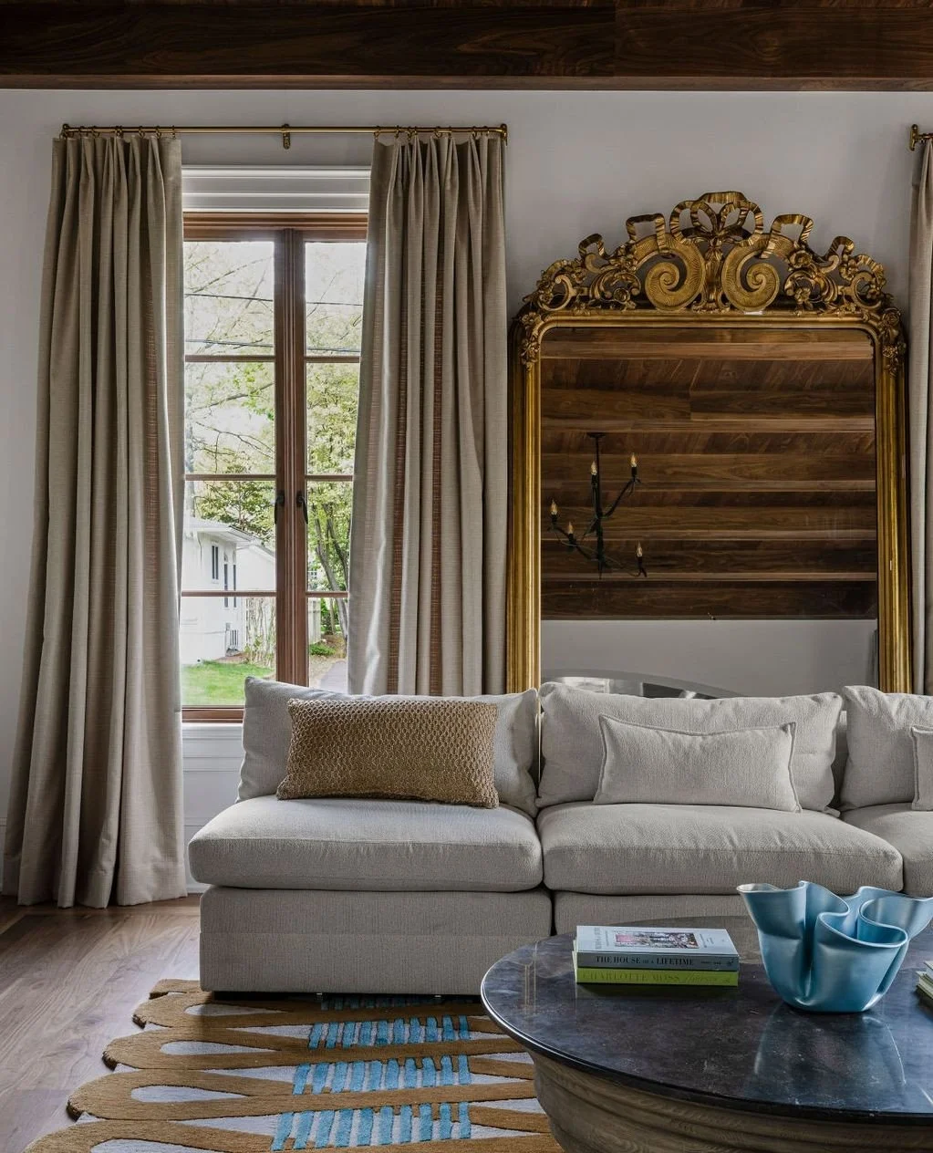A family room designed for both ease and elegance.⁠
Warm walnut ceilings, natural light, and an oversized gilded mirror create a rich architectural backdrop, while the furnishings soften the space with a calm, collected mood.⁠
⁠
In collaboration with
