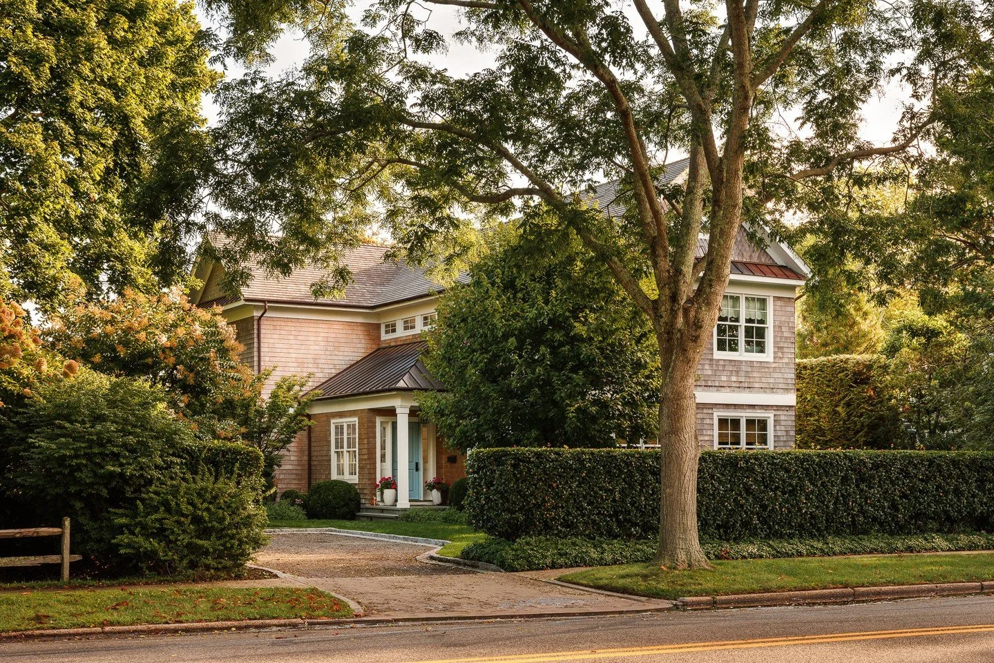 Approached through a gravel drive framed by mature trees and clipped hedges, the home reveals itself with quiet restraint. The cedar shingles, metal roof, and crisp trim speak to East Hampton&rsquo;s architectural lineage&mdash;balanced here with mod