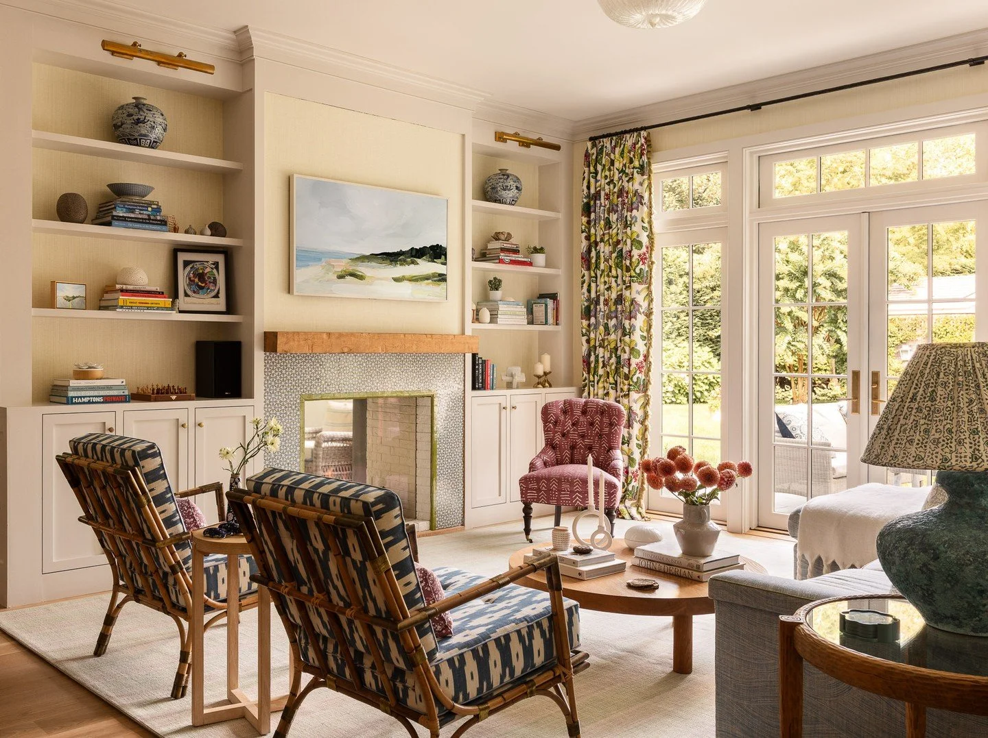 Built-in bookcases frame a see-through fireplace that links the living room to the screened porch beyond. The kitchen, just to the left, continues this open flow of light and movement through the main floor. Designed in collaboration with Sara Gilban