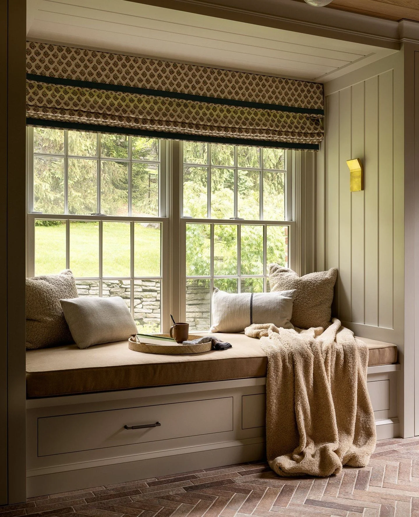 Tucked within the architecture, this custom window seat transforms an overlooked corner into a place to pause. Integrated millwork wraps the window opening with paneling, built-in storage below, and a tailored seat designed for quiet moments and natu