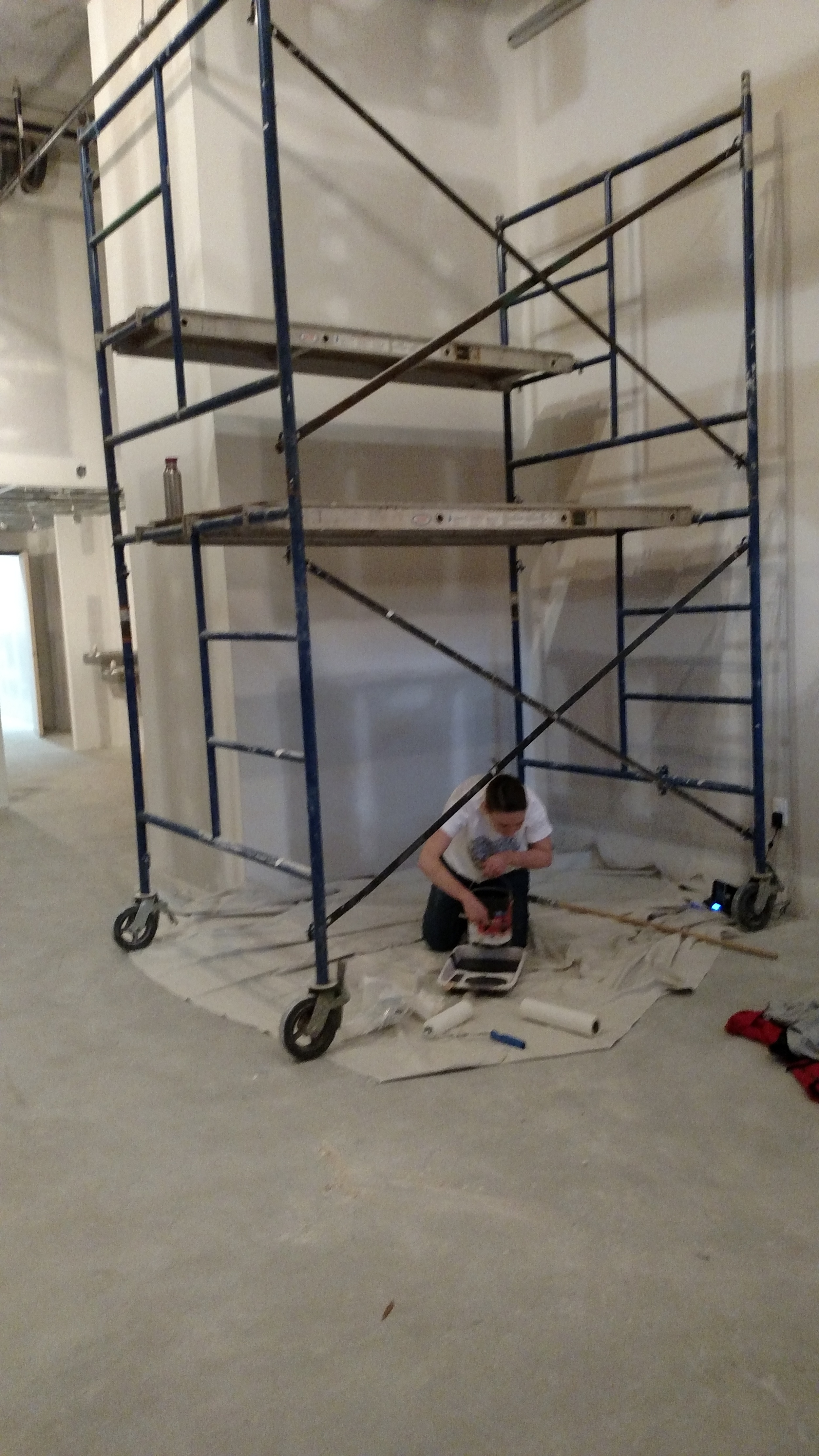 Preparing to paint the wall black before putting up the pallet wood