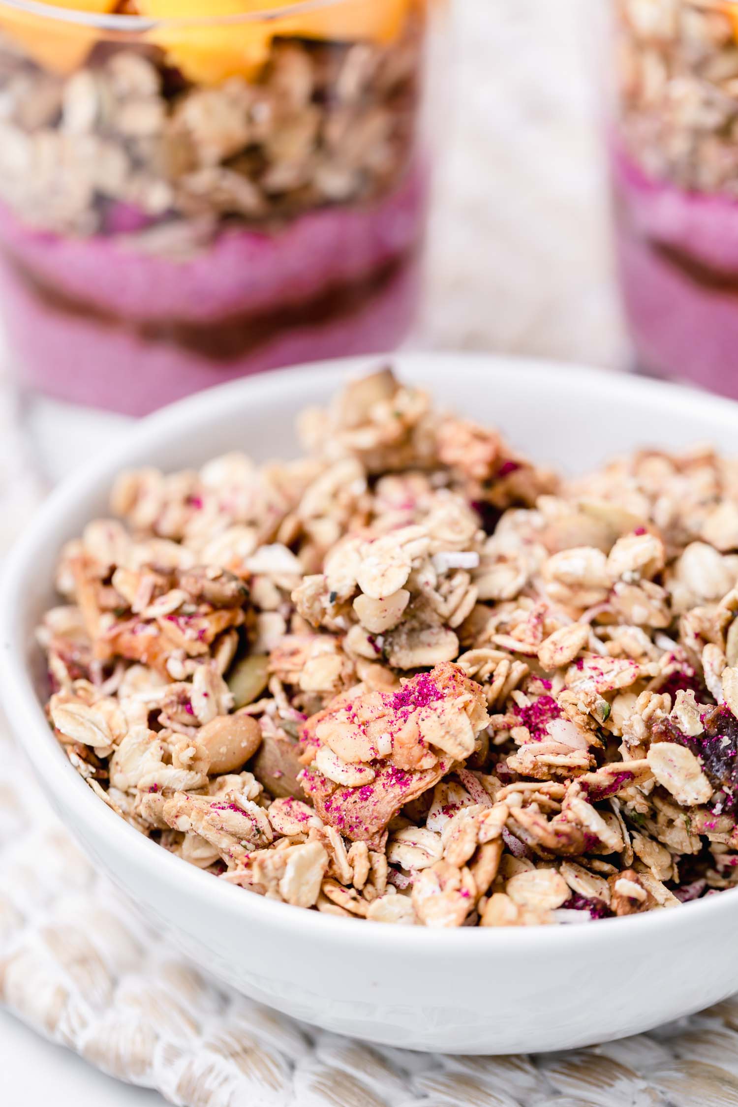 Tropical granola flavored with banana, pineapple, coconut, and macadamia nuts and dusted pink with pitaya (dragon fruit) powder. #tropicalgranola #granolarecipe #summerrecipe #summertime #tropical #tropicalrecipe #vegangranola #veganrecipe #glutenfreevegan #pinkfood