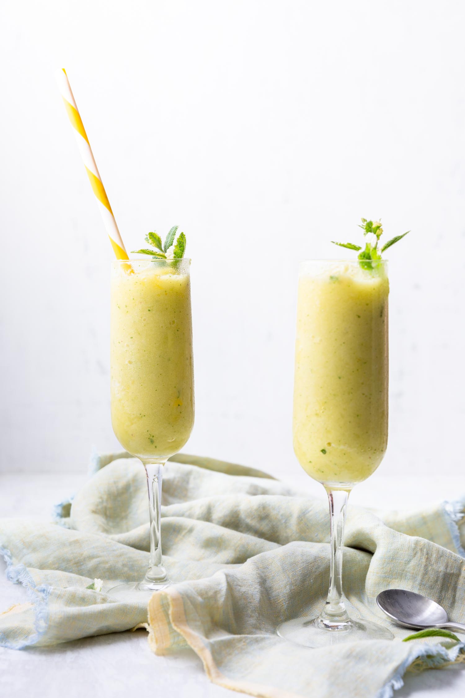 Pineapple Mint Frozen Drinks require just two ingredients (+ water) for a delicious and refreshing mocktail - add your favorite spirits for the ideal summery cocktail. #summerdrink #summercocktail #cocktail #pineapple #pineapplemintrecipe #drinkrecipe #frozendrink #blended #mocktail #fruitydrink #tropicaldrink #mojito
