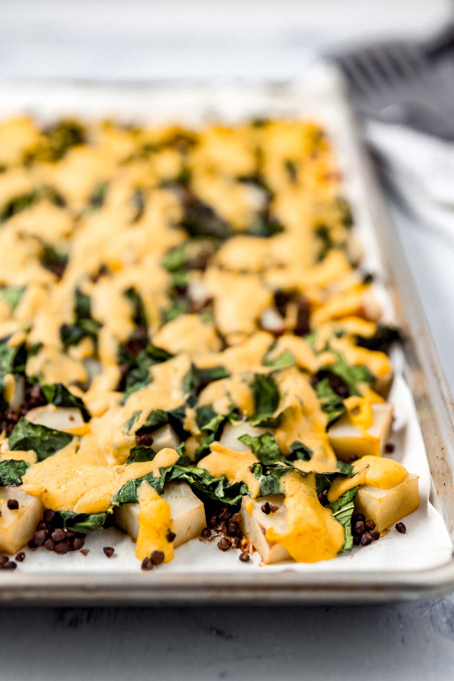 Cheesy Vegan Sheet Pan Potatoes with Greens and Lentils makes a full, satisfying meal. #plantbased #dinner #cheesy #vegan #cheesesauce #wfpb #glutenfree #grainfree #oilfree #greens #kale #collards #lentils #veggies #sheetpan #comfortfood