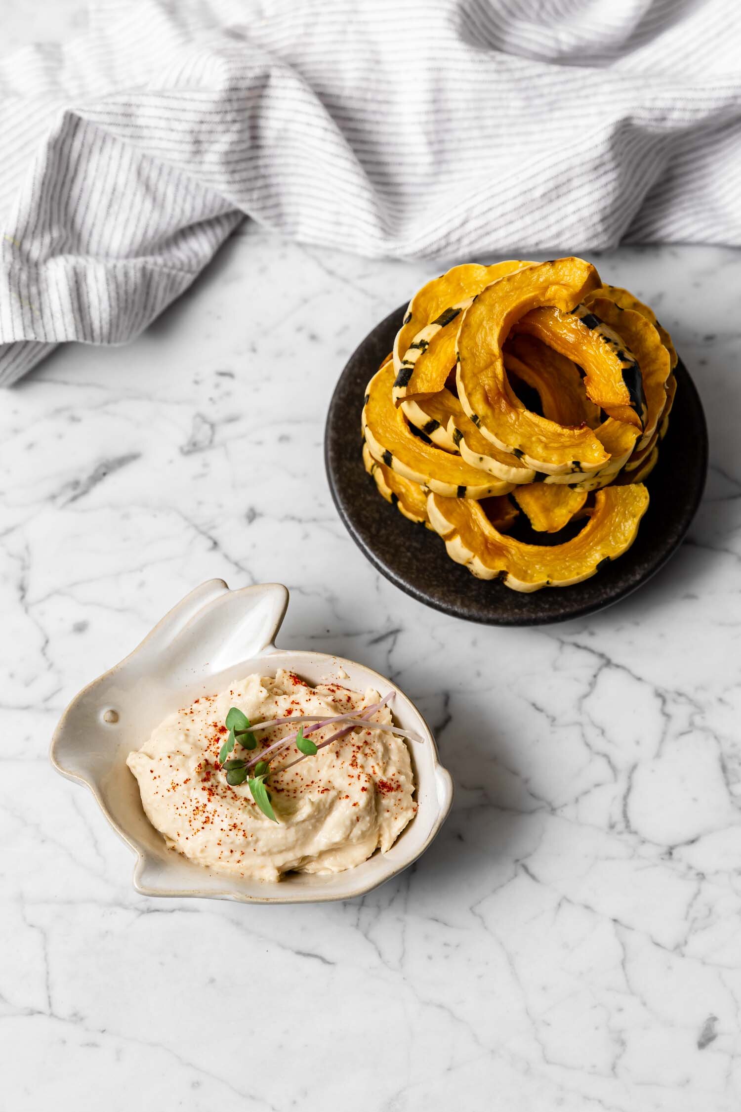 Delicata Dippers, a one-ingredient satisfying snack that takes just 5 minutes to prepare, are cooked and ready to eat within 25 minutes, and taste wonderful dipped in hummus or another savory dip. While a carrot or celery stick might not replace chips or crackers easily, these will! They’re filling and great for weight loss. #delicata #squash #weightloss #snack #weightlosssnacks #easyrecipe #oneingredientrecipe #readyin30minutes #wholefoodsnack #chipreplacement #crackerreplacement