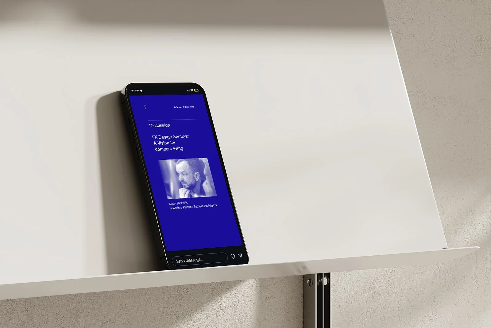 Smartphone displaying a discussion about a design seminar on a white shelf.