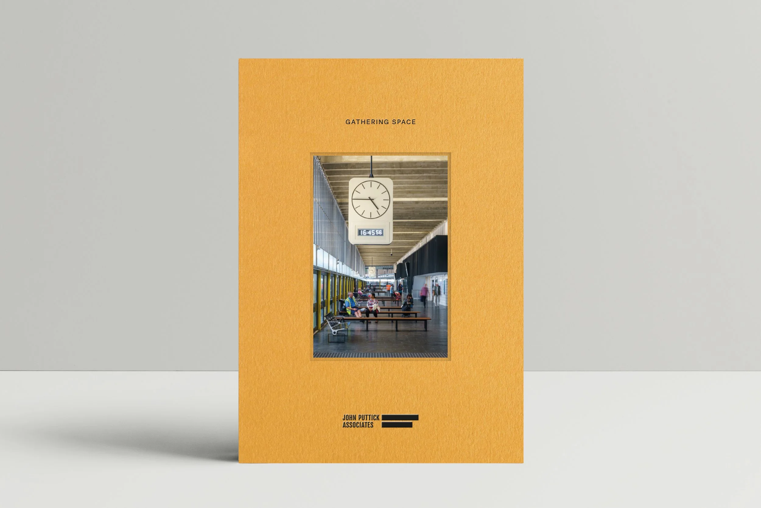 A brochure featuring an interior scene of a modern train station or bus terminal with a large clock hanging from the ceiling, benches, and passengers waiting or walking, with the title 'Gathering Space' and the author 'John Puttick Associates' on the front.