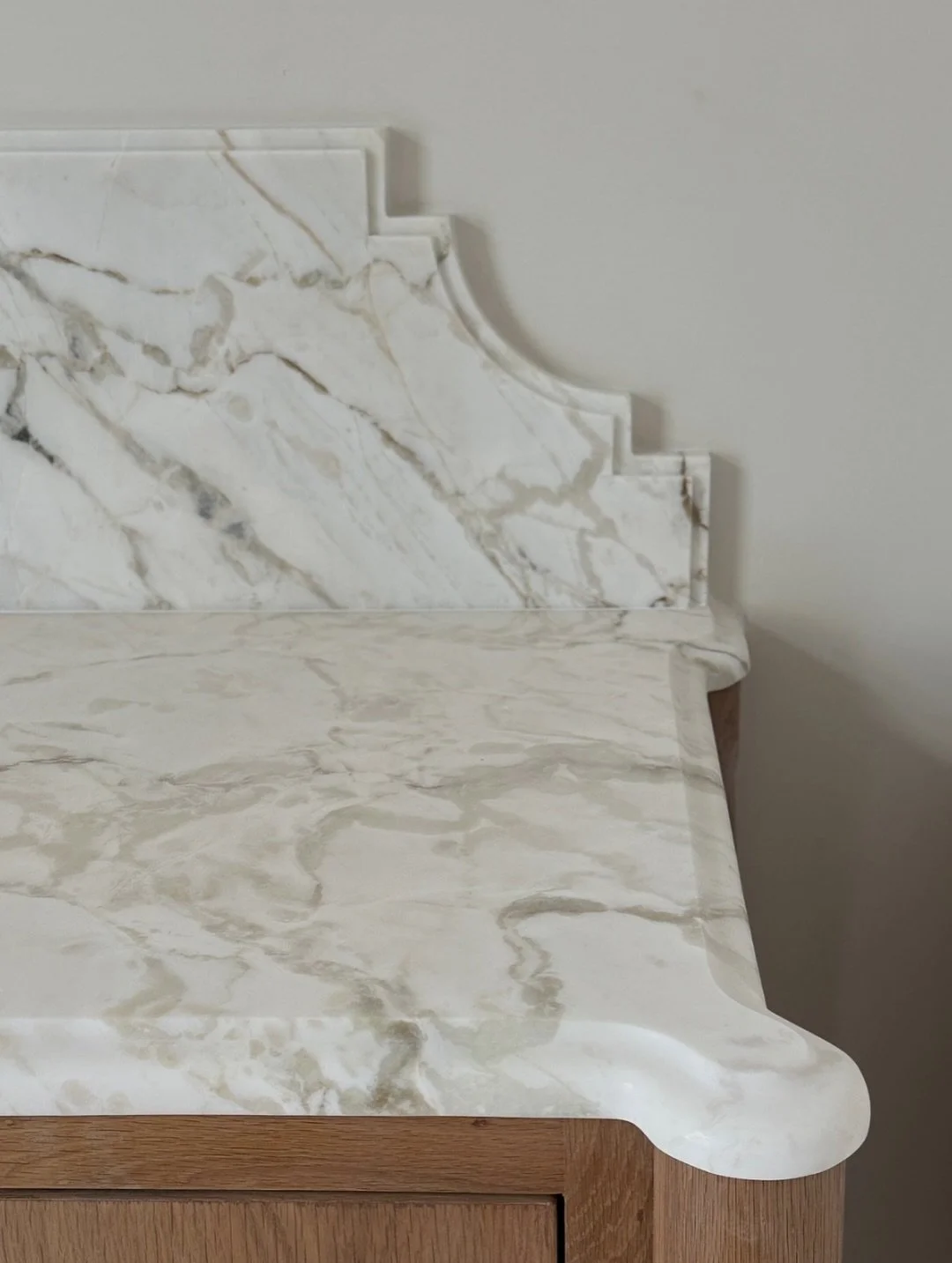 Calacatta Saba with an ogee edge flows seamlessly around rounded corners, paired with custom furniture-style cabinetry and a French cove backsplash detail&mdash;together creating a true statement piece.

#stonemode #luxury #stone #dallasinteriordesig