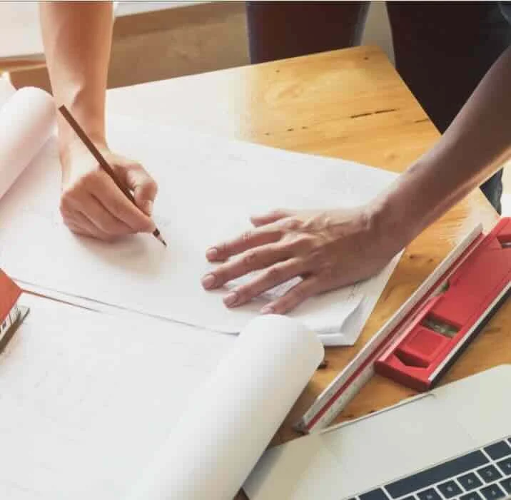 Working hands drawing architectural plans 