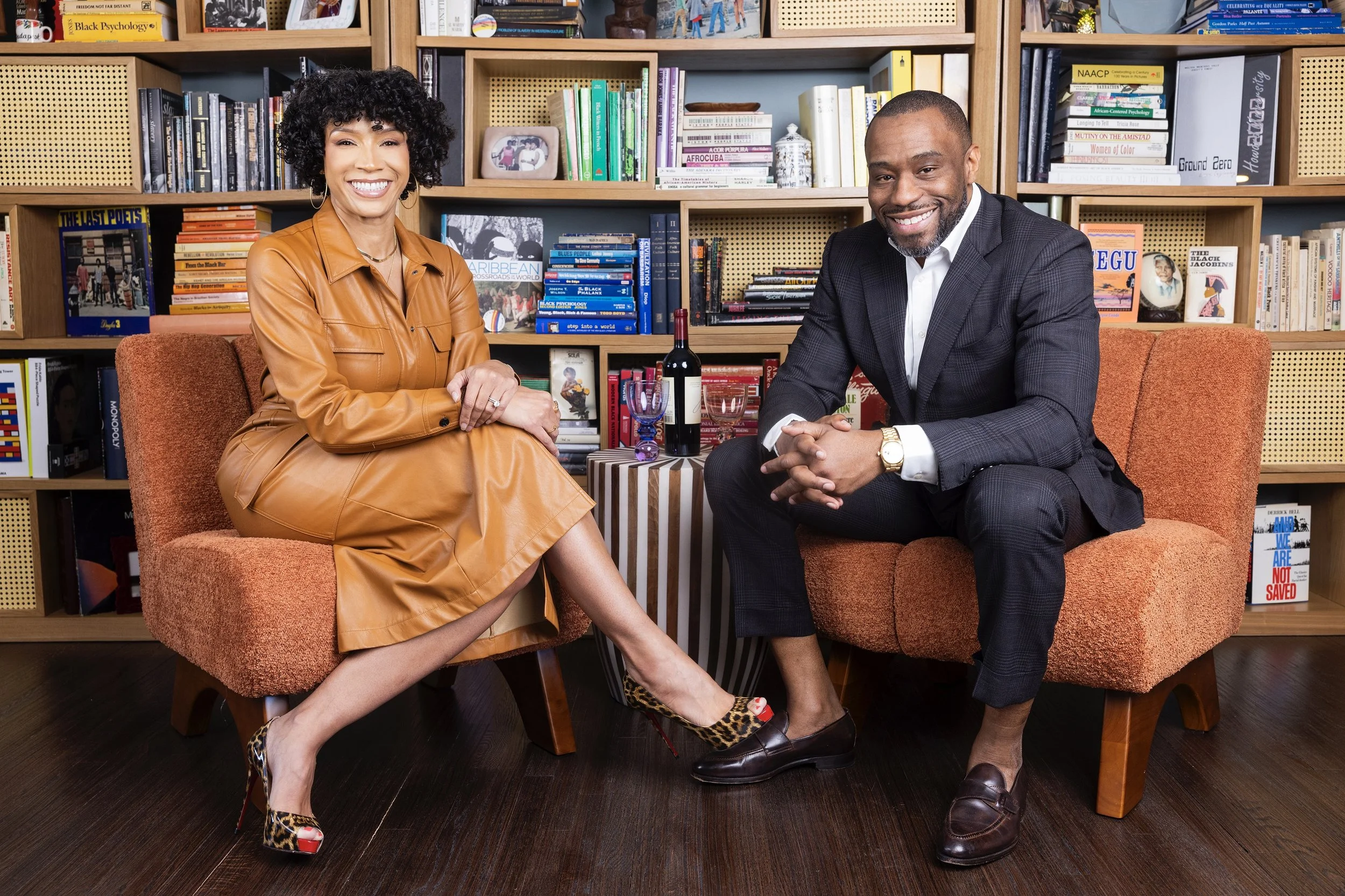 melissa and marc sit in front of living room bookcase in their home