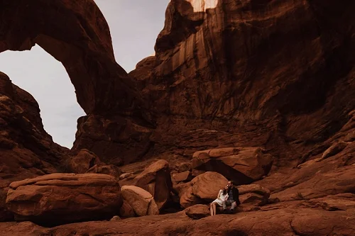 Couple engagement shoot under arch in Moab Utah