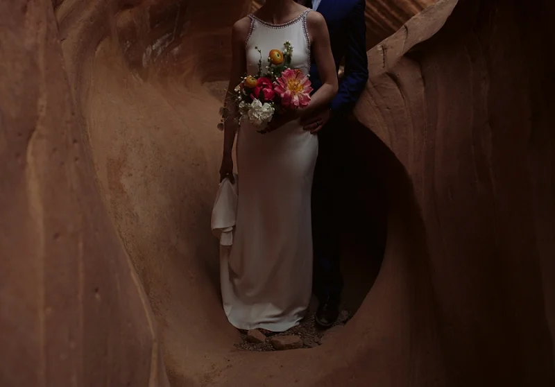 Bride holds flowers in slot canyon