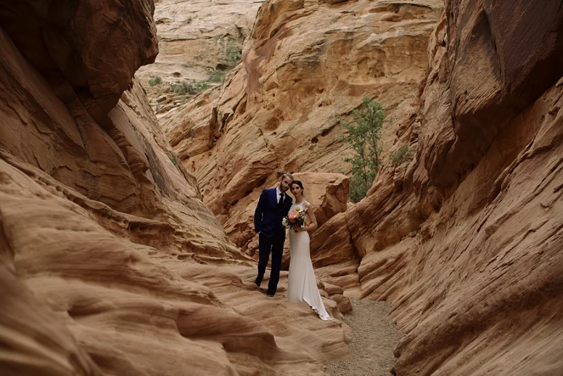 Couple stands in the southwest’s red rock desert near Moab Utah