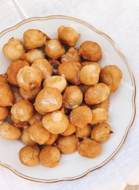 Freshly fried fritule sprinkled with sugar