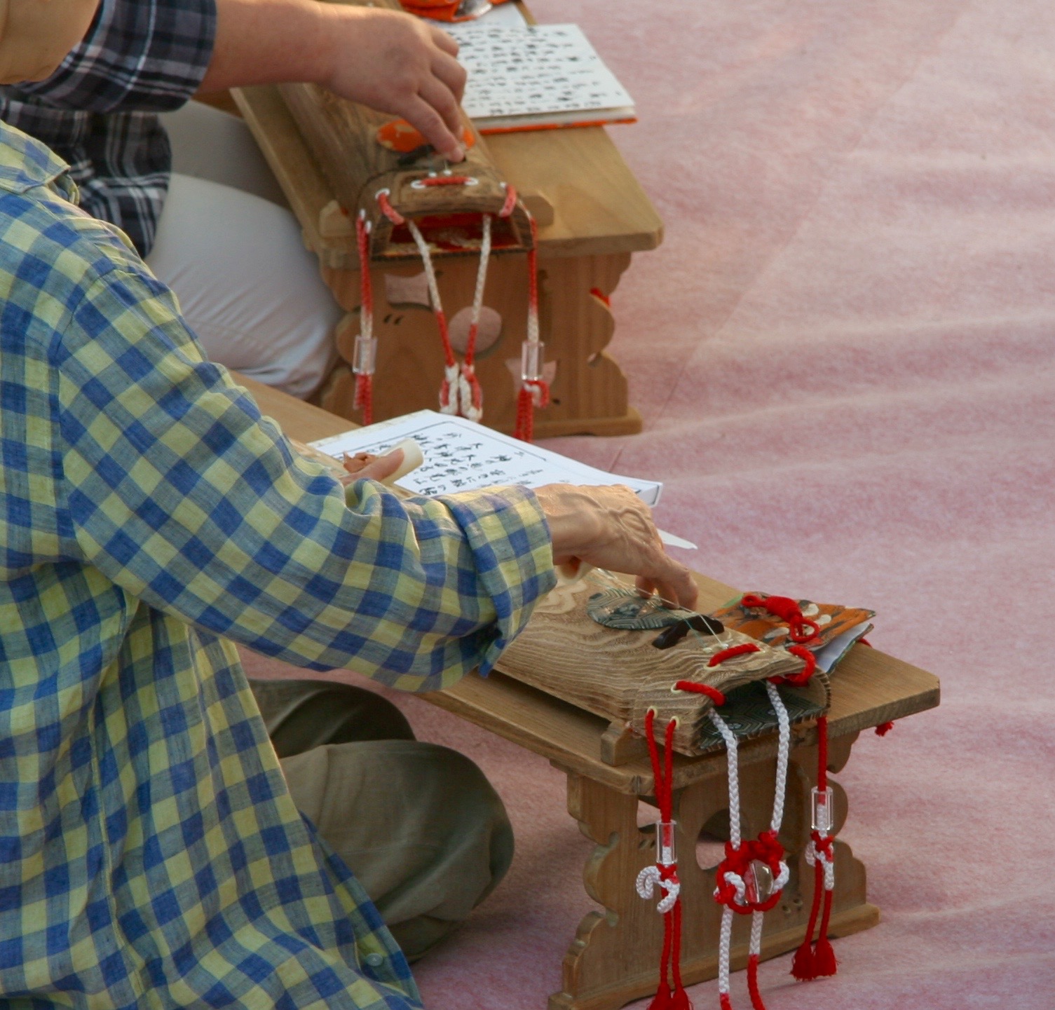 Women practice playing the koto ahead of the ceremony