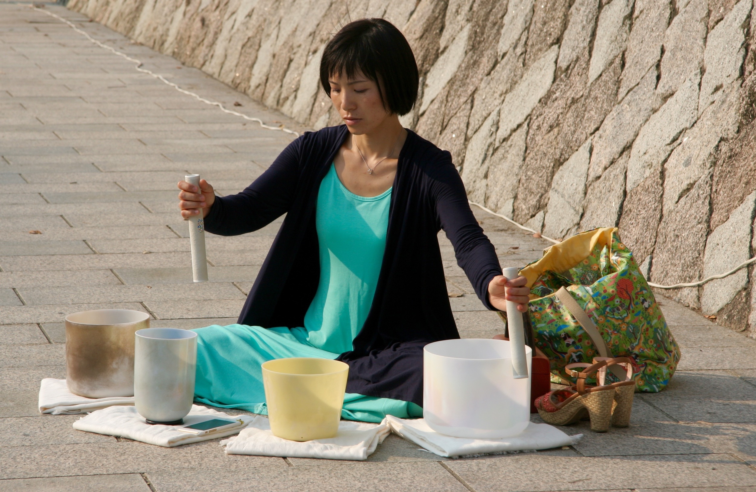 A woman using crystal glass to create haunting tunes that floated across the river