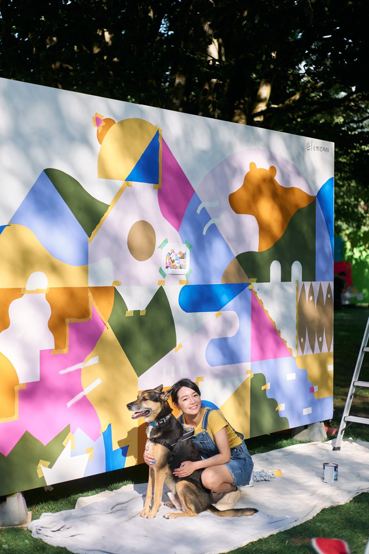 Annie working on her mural for Squamish Mural Fest, posing with her dog Sammy.