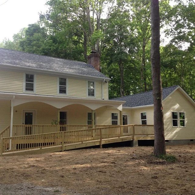 New Front elevation of existing house, with new siding and new roof and the new addition with porch and ramp.