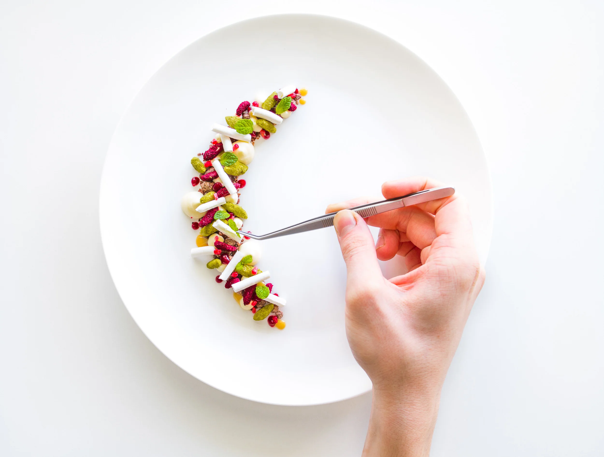Vanilla curd, matcha and beetroot almond, berry sauce, dulce de leche, raspberry segment, chocolate rocks and meringue