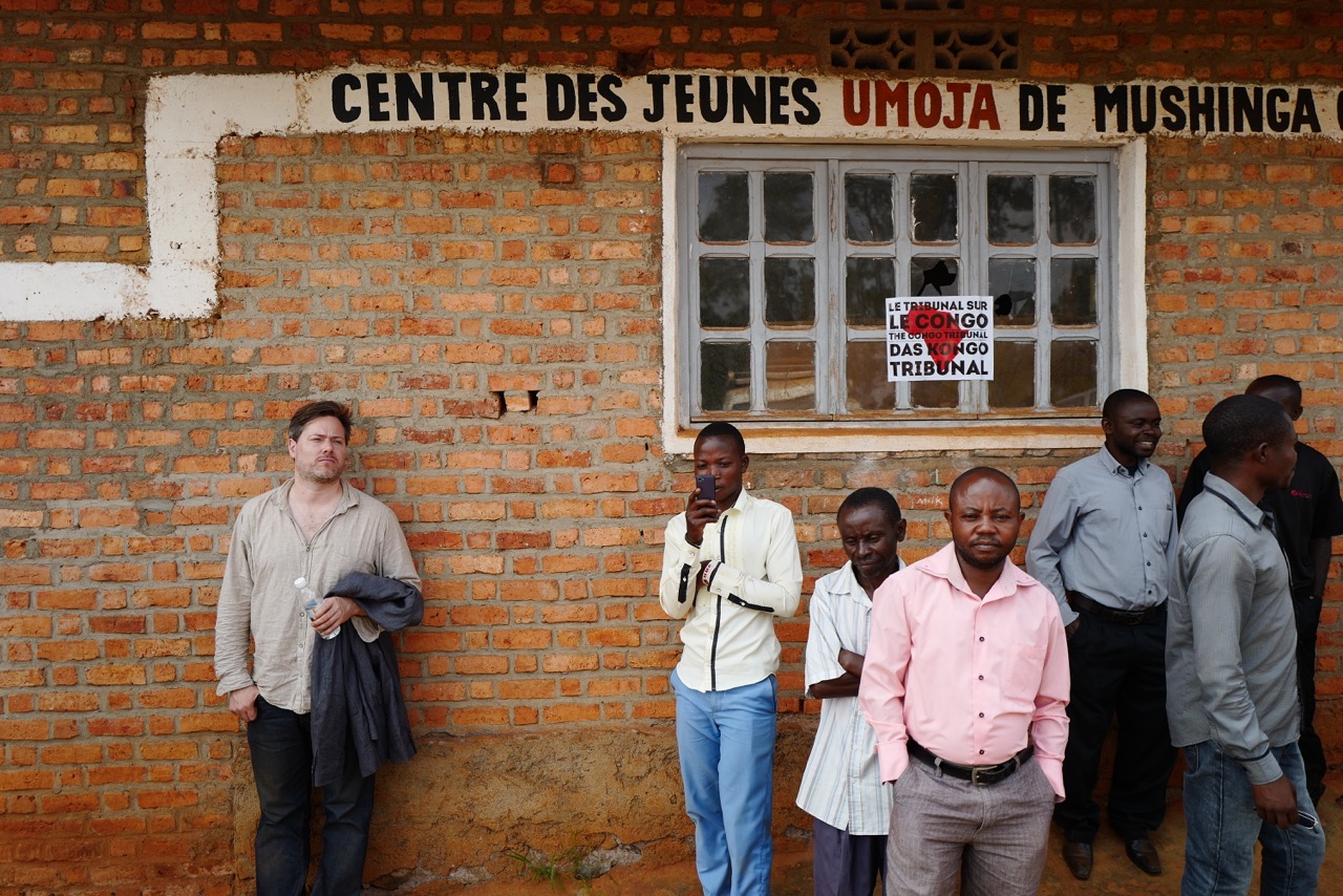 Milo Rau waiting for the screening in front of peasants and artisanal miners in the village of Mushinga. (@2017 The Congo Tribunal / Arne Birkenstock)