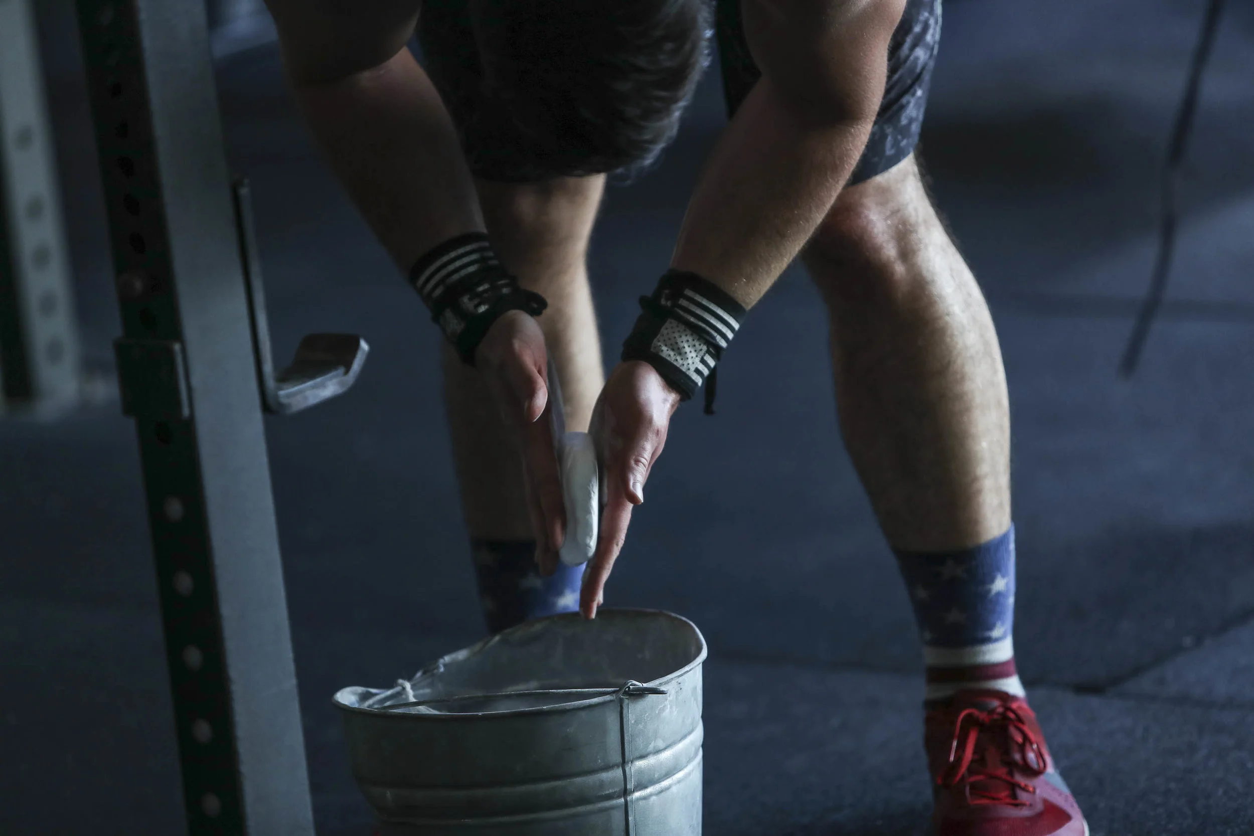 Ryan Kealler showing the proper way to chalk your hands. You put your hands in bucket, chalk while hands are still in bucket. Clap away excess over bucket, then go lift some shit.