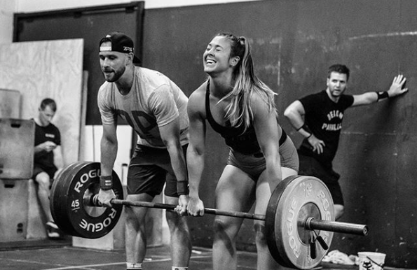 Ryan and Rebecca doing partner deadlifts as Greg makes sure the wall doesn’t move on them.
