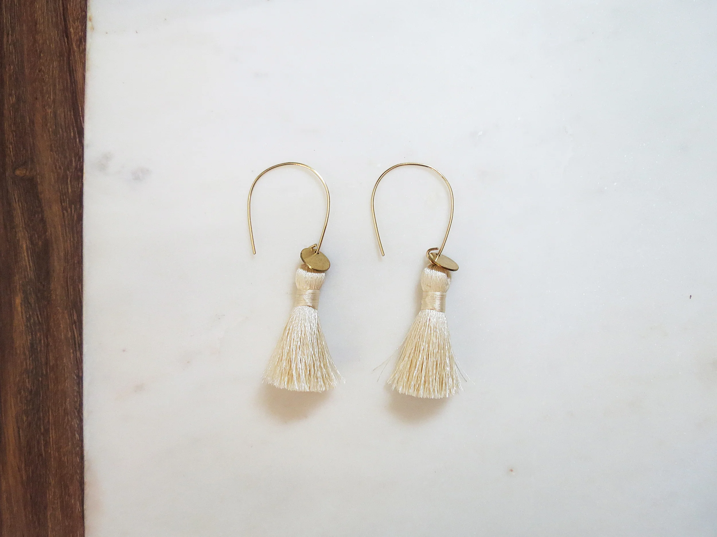 Sun Salutations minimal modern handmade jewelry gold raw brass disc, nylon silk tassel + gold-filled wire earrings side view white creme