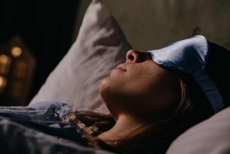 woman asleep wearing eyemask.