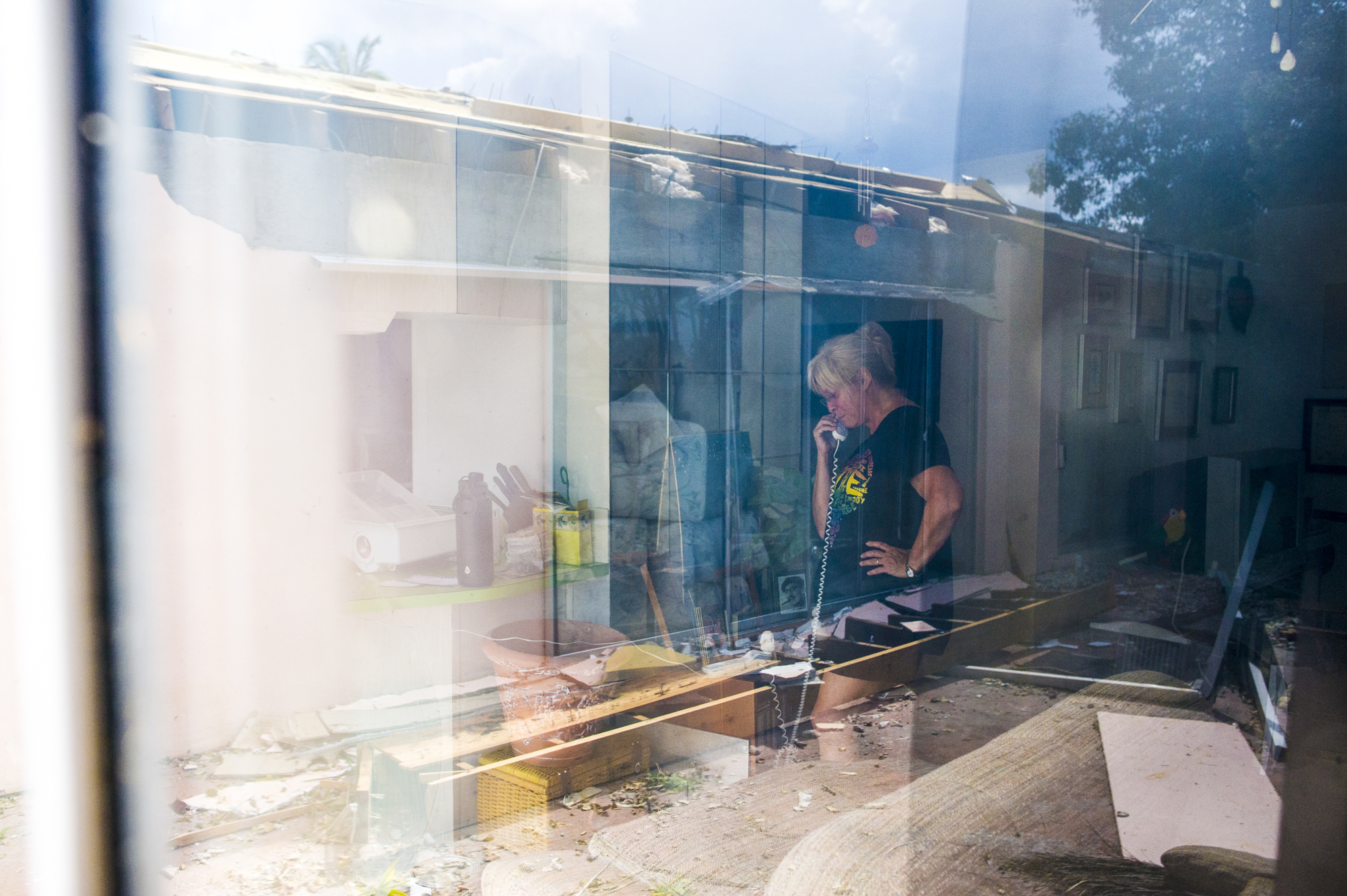 Laura Kirkman Leary talks with a person who has offered her a place to stay after her roof and lanai were destroyed by winds and flooding.