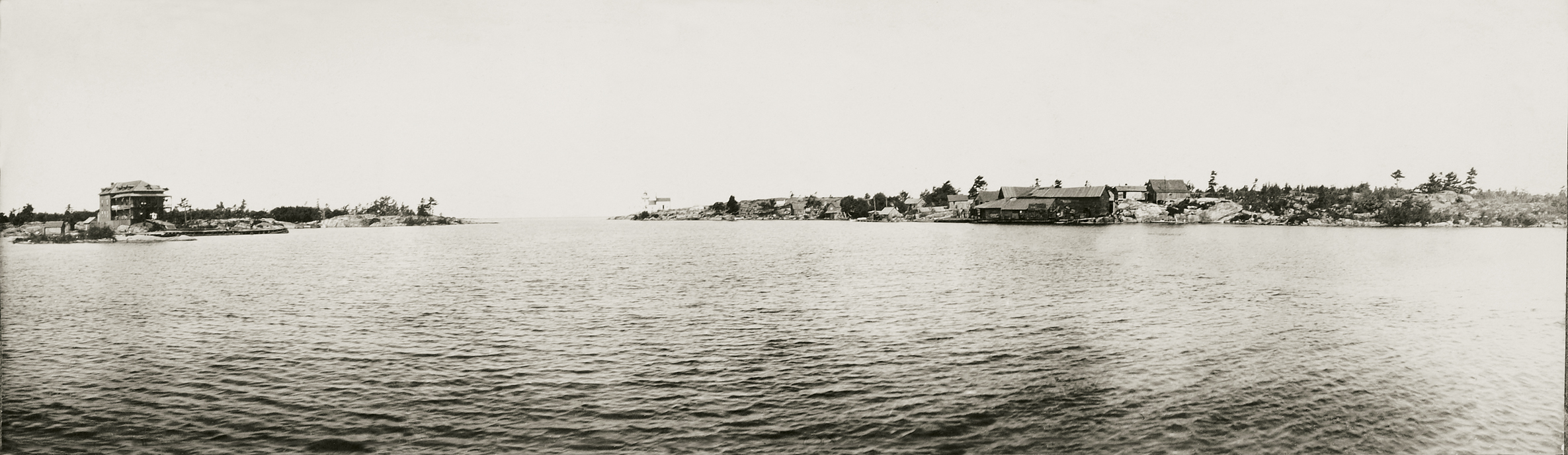 A view to the open water featured the Bellevue Hotel to the left and the lighthouse and John McIntosh’s fishing facilities to the right. Relaxing on the front porch was a prime activity for vacationers in Pointe au Baril.