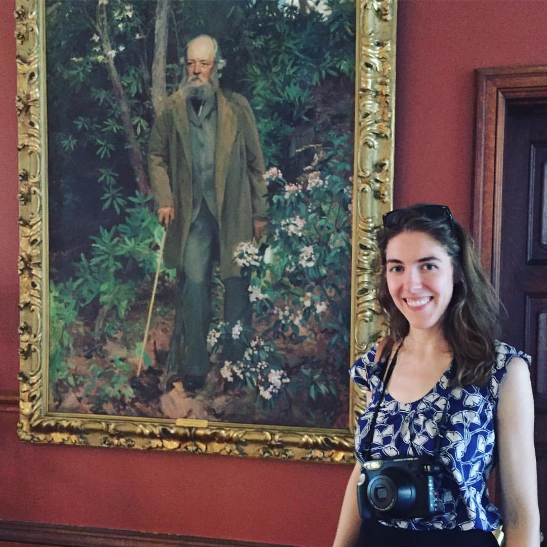 Ashley Yazdani stands next to a painting of Frederick Law Olmsted, one of the creators of Central Park.