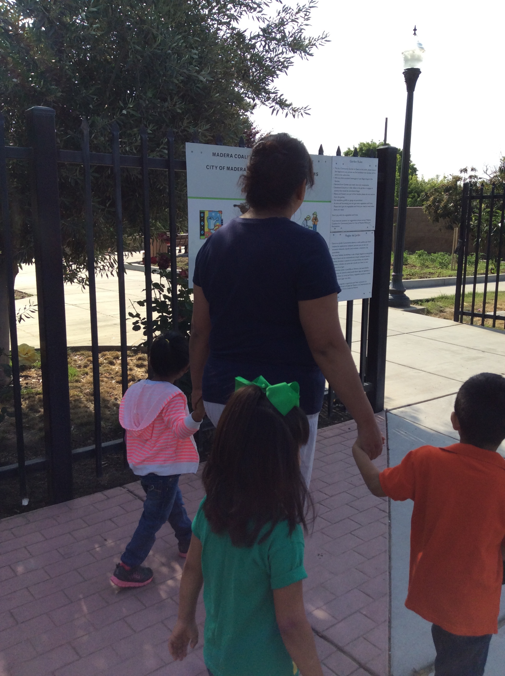 One of the teachers walk with children on field trip to Madera Community Garden to plant sprouted vegetable plants in celebration of Earth day.
