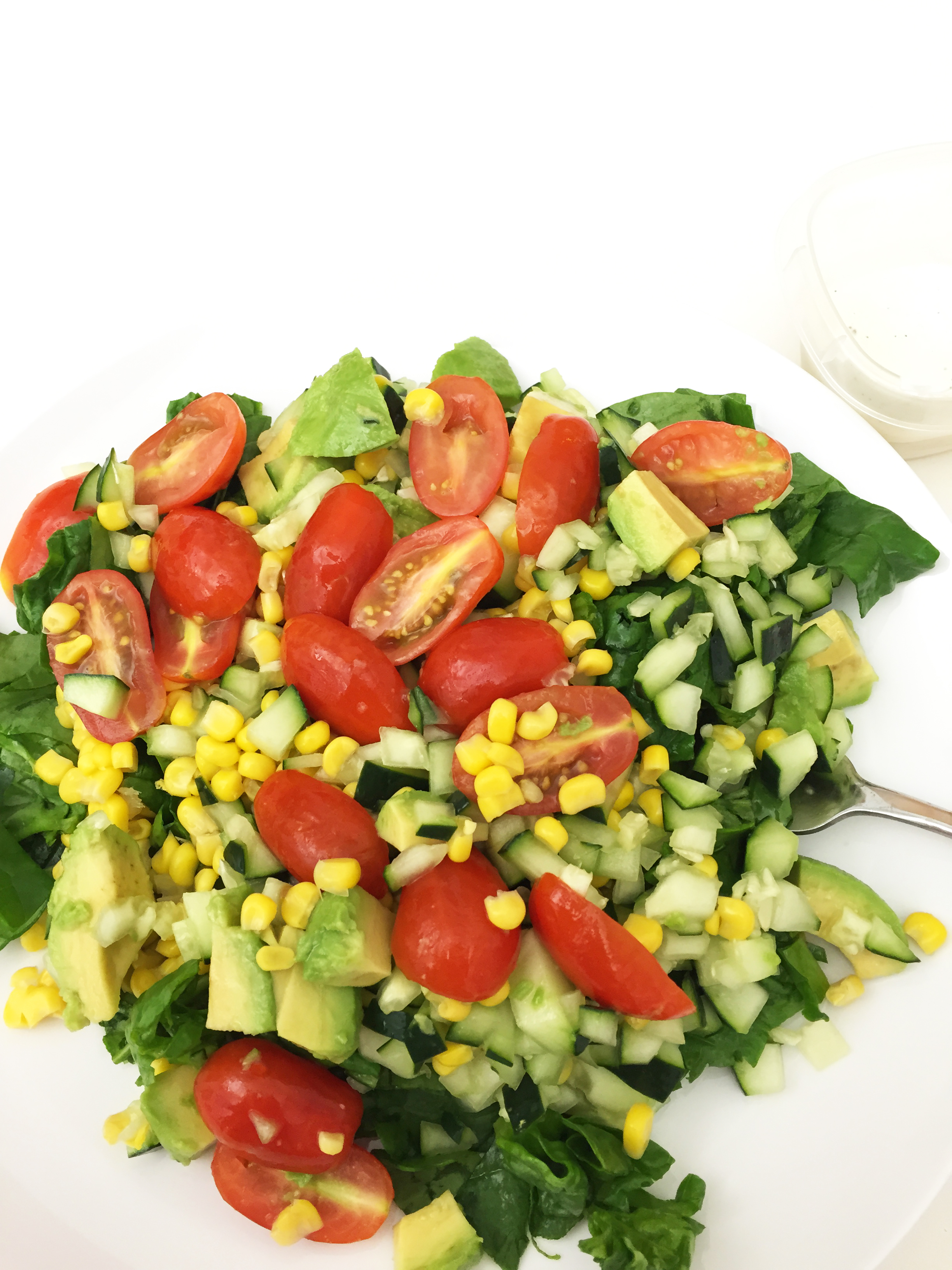 Tomatoes, cucumber, corn, avocado, spinach. Ranch on the side.