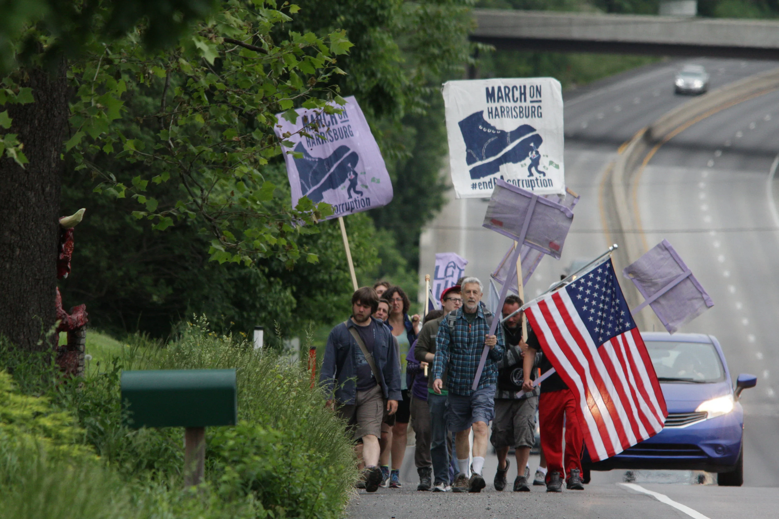 A group of demonstrators, some of whom marched more than 100 miles from Philadelphia over the course of nine days, walk down the shoulder of US Route 322 near Hershey, PA, Sunday, May 21, 2017. The organizers plan on staging actions at the State Capitol building starting Monday, including planned civil disobedience.