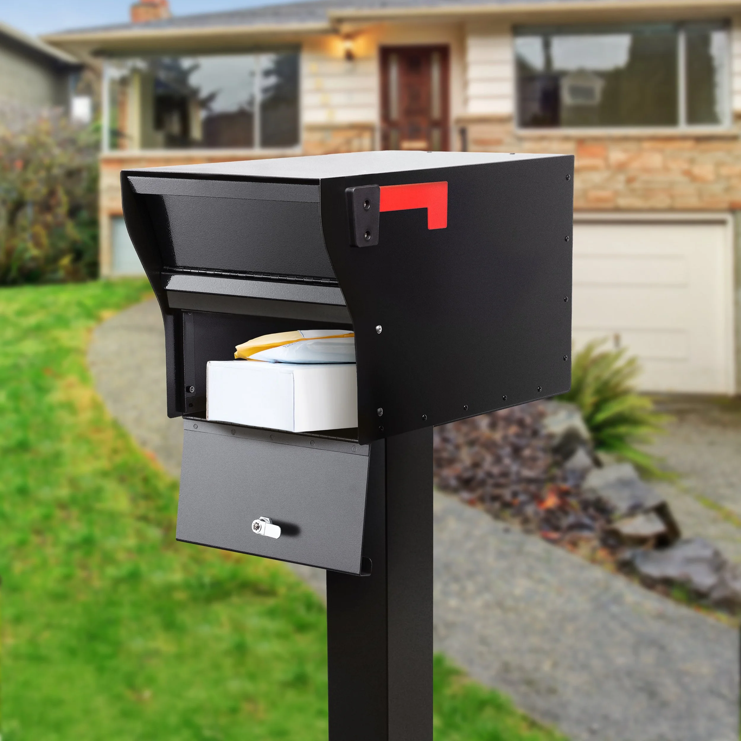 A black mailbox with a red flag is mounted on a black post in a suburban front yard with a house, lawn, and sidewalk in the background.