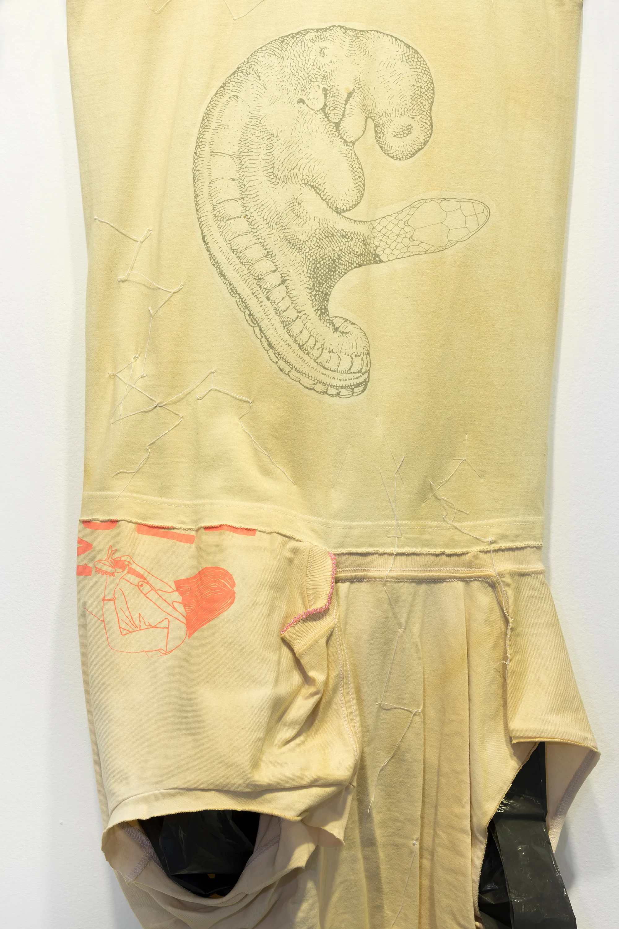 Detalj av Leif Holmstrand, Costume for a New Tail (It’s a Girl) (2015), textile wall sculpture: T-shirt fabric, print depicting human fetus plus snake head, garbage bag plastic, pearls et cetera. Foto: Øyvind Thorvaldsen