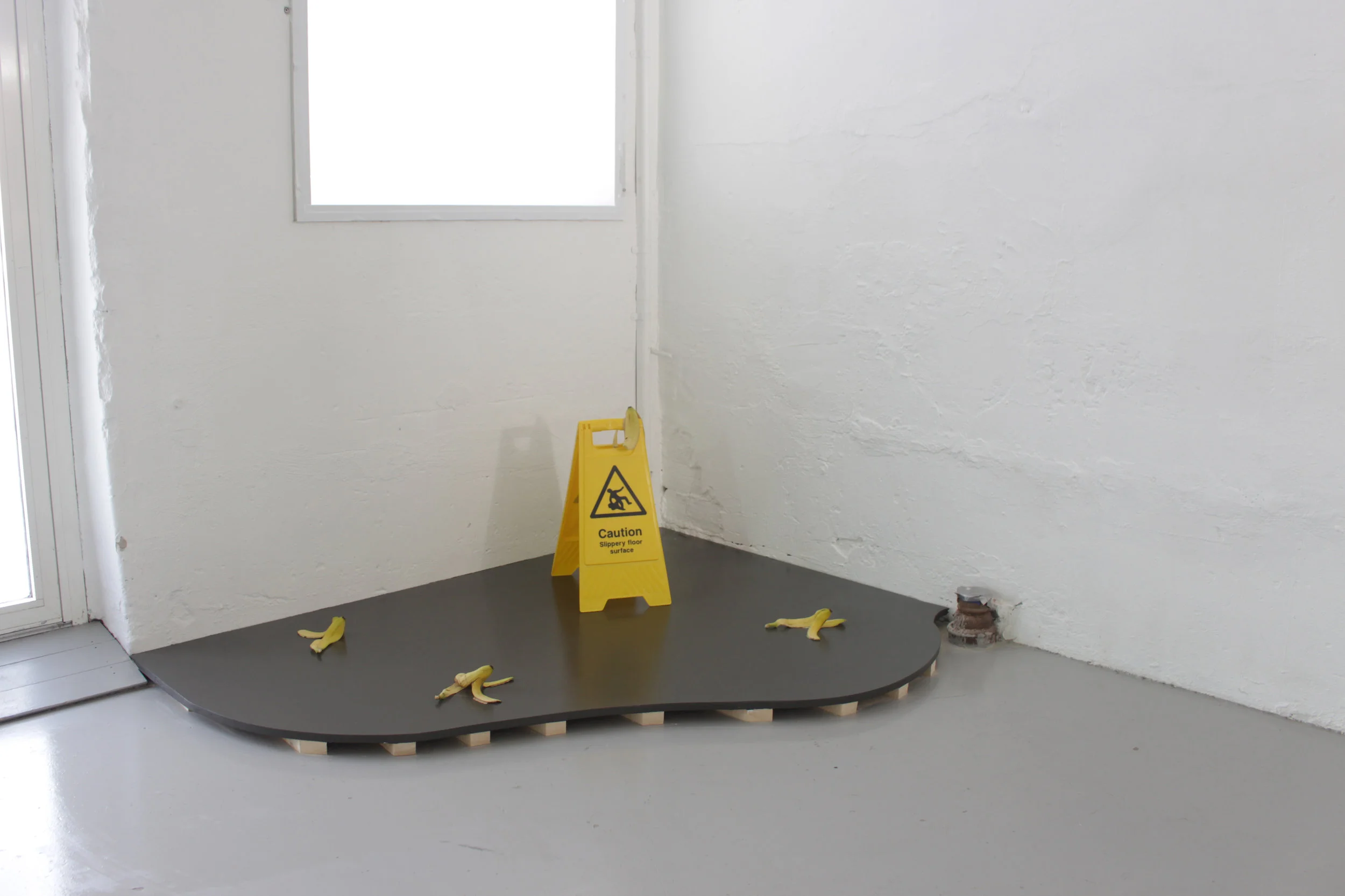 Untitled , 2018, dimensions variable (wood , slippery surface sign, banana peals). Foto: Audun Alvestad