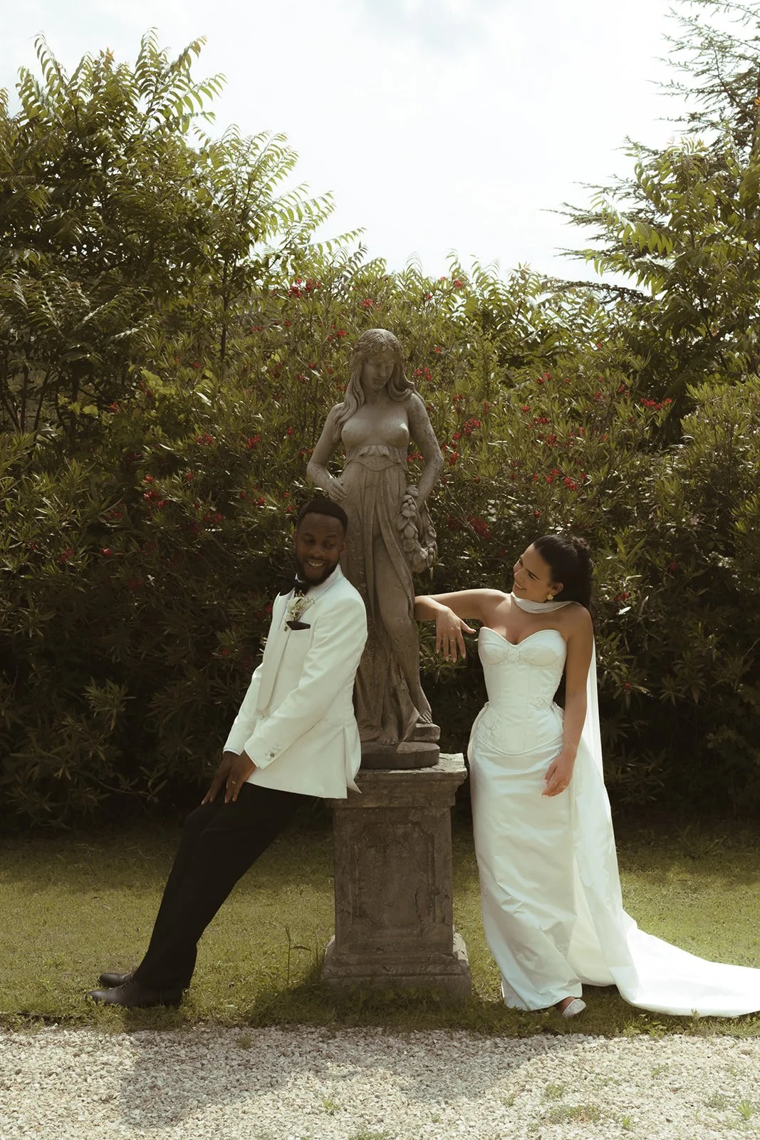A bride and groom married in France - she is wearing a corsetted gown with a cupped corset, column dress, and detachable train in ivory duchess satin