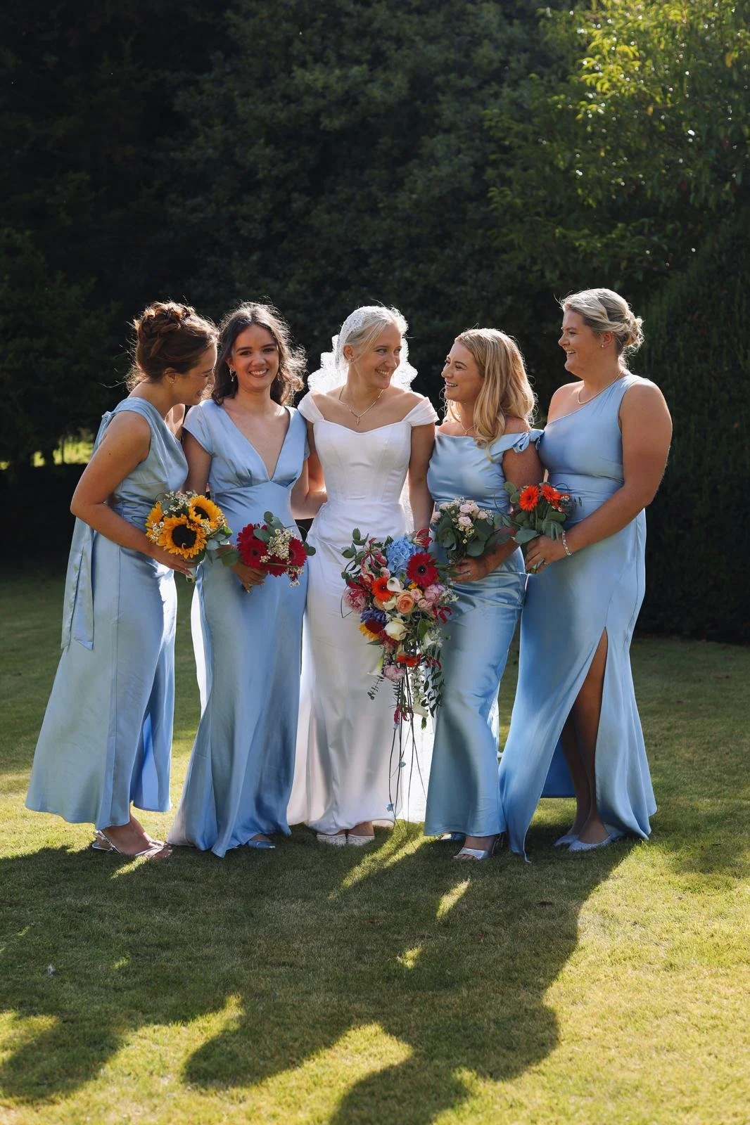 A bride wearing a corsetted gown with her bridal attendants